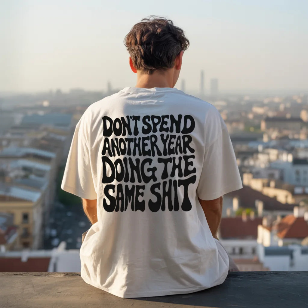 Don’t Spend Another Year Doing The Same Shit (Backprint) Oversized T-Shirt White – Steel Spirit, worn outdoors on rooftop view